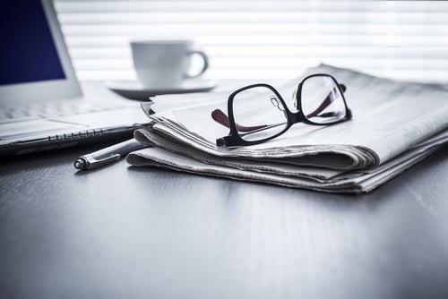 A pair of glasses and a pen on top of a table.