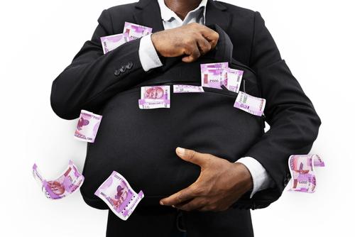 A man in a suit holding onto some money