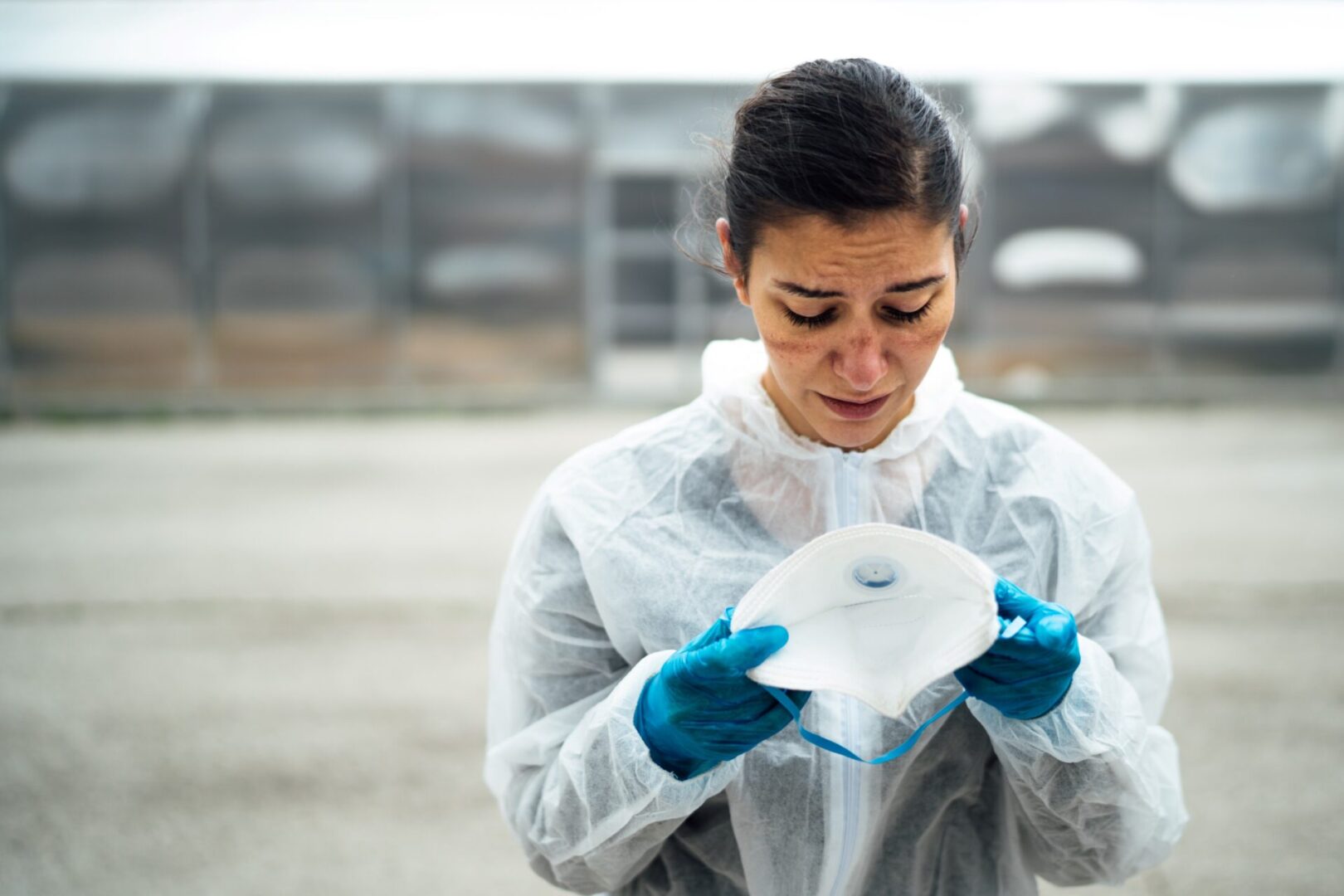 A woman in white jacket holding up an object.