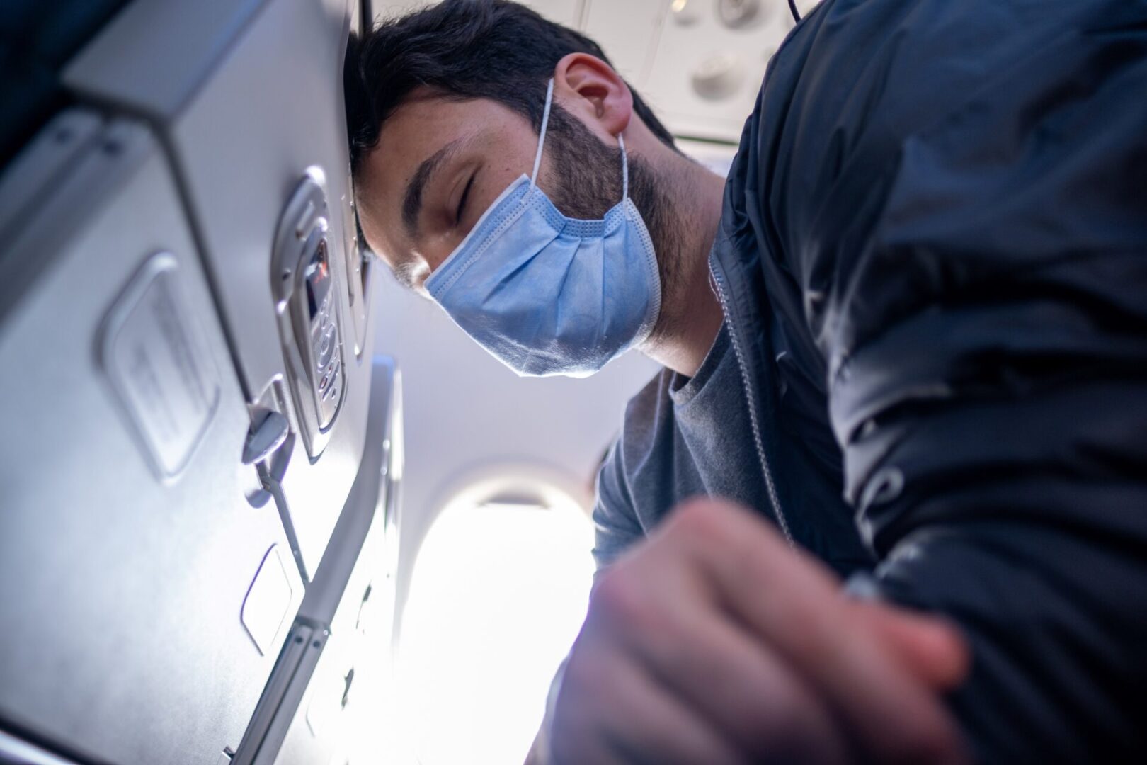 A man wearing a mask on top of an airplane.