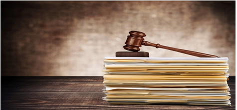 A judge 's gavel sitting on top of papers.