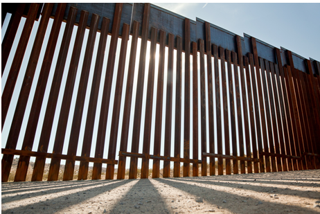 A fence that is made of wood and metal.