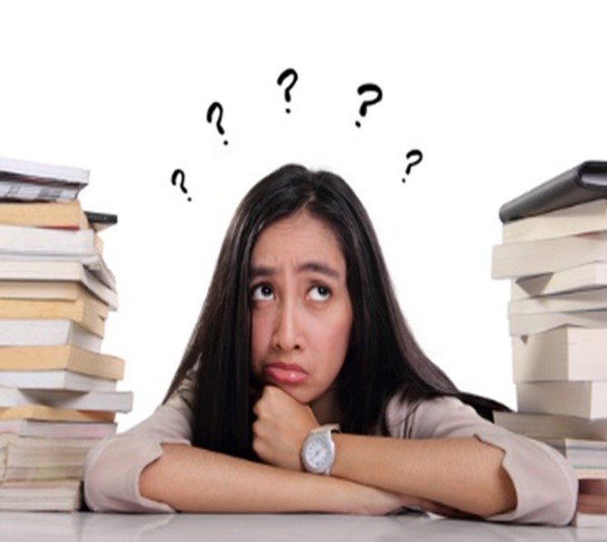 A woman sitting at her desk with books and papers