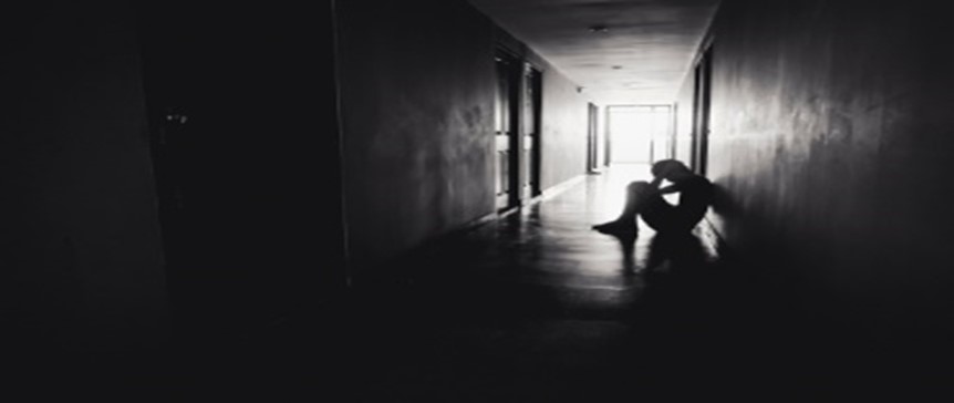 A person sitting on the floor in front of an open door.