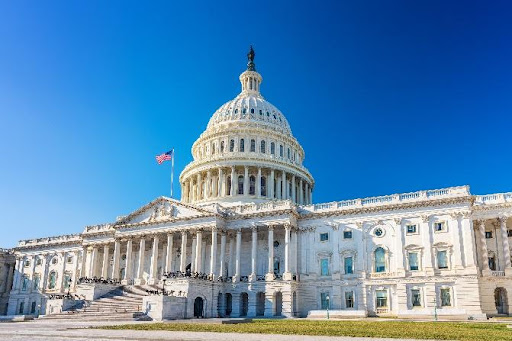 A large white building with an american flag on top of it.