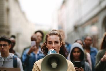 A woman is holding a megaphone in front of her face.