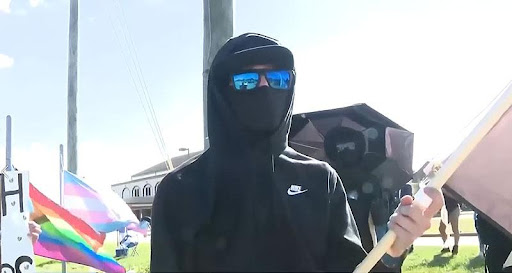 A person wearing sunglasses and a black hoodie.