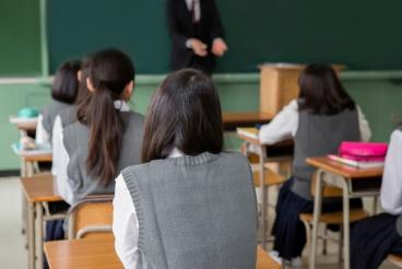 A group of students sitting in front of an adult.