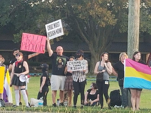 A group of people holding signs in the grass.