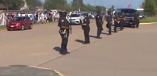 A group of police officers standing in front of a crowd.