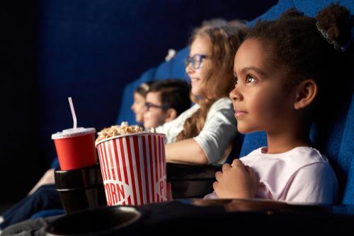 A group of people sitting at the movies watching something.