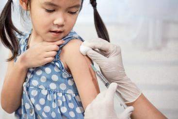 A child getting an injection from someone else