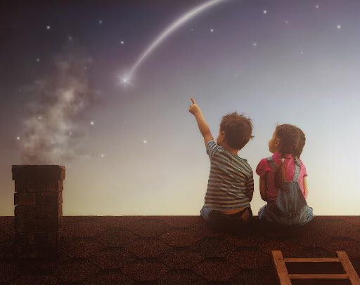 Two children sitting on a roof looking at the sky