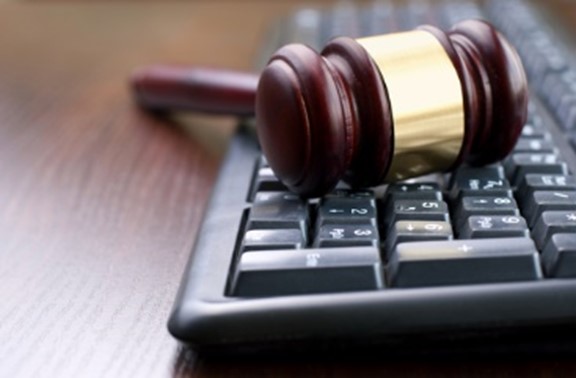 A wooden gavel sitting on top of a keyboard.