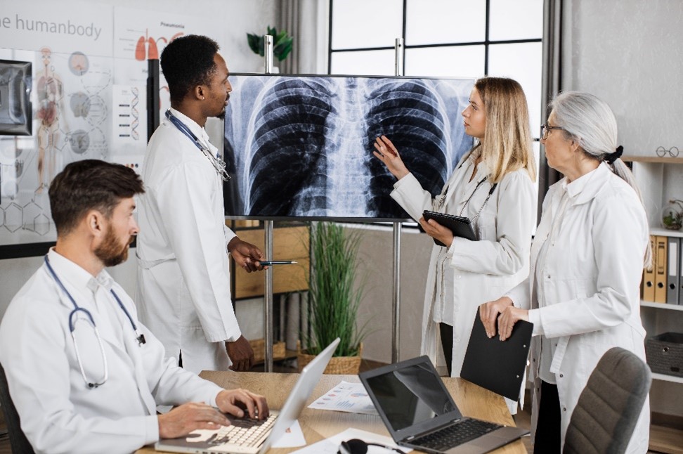 A group of doctors are standing around a table.