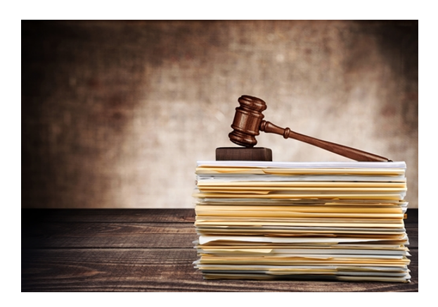 A judge 's gavel sitting on top of papers.