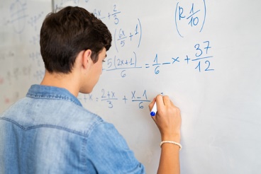 A boy writing on the wall with a marker