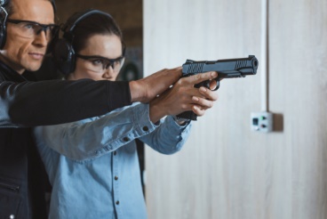 A man is holding a gun and wearing headphones.