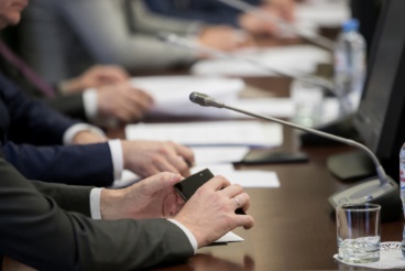 A group of people sitting at a table with papers.