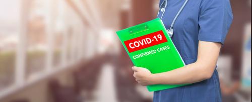 A person holding a green folder with the words covid-1 9 confirmed cases on it.