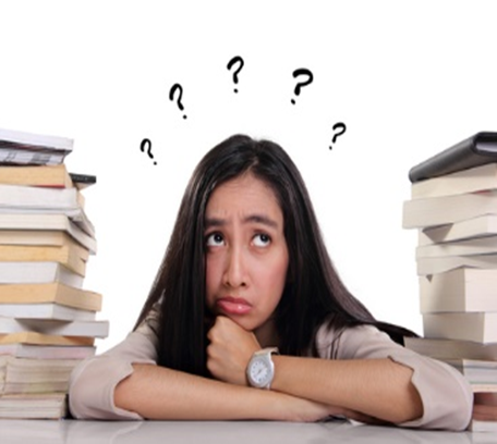 A woman sitting at her desk with books and papers in front of her.