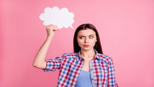 A woman holding up a thought bubble in front of her face.