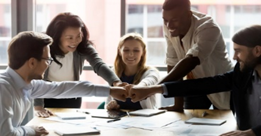 A group of people holding hands at a table.