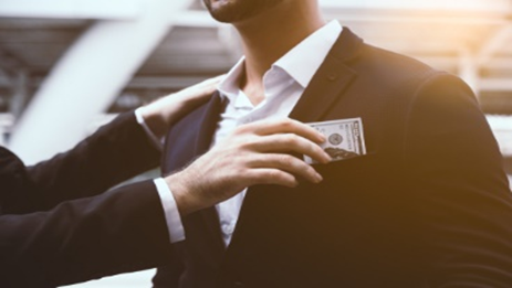 A man in a suit holding money in his hand.