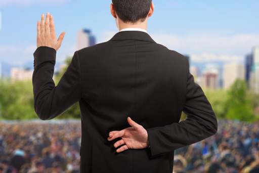 A man in a suit is holding his hand up to the sky.