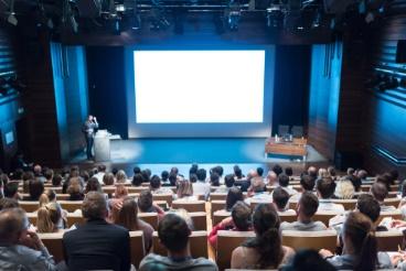 A group of people in front of a projector screen.