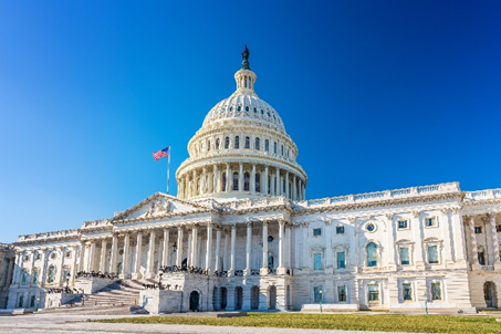 A large white building with an american flag on top of it.