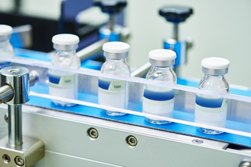 A row of empty bottles on top of a conveyor belt.