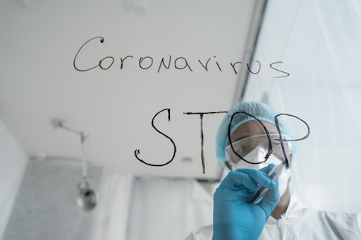 A person in blue scrubs writing on glass