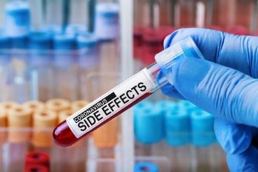 A person holding a blood sample in front of many other blood samples.